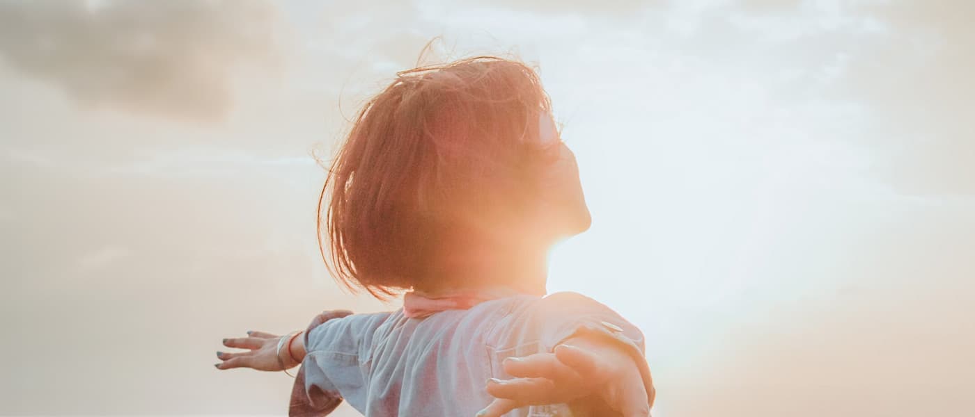 Person standing in sunlight outdoors